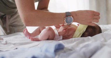 Beyaz bir annenin bebeğini değiştirdiği orta bölüm videosu. annelik, ebeveyn sevgisi ve yeni doğan bebek konseptiyle ilgilenmek dijital olarak üretilmiş video.