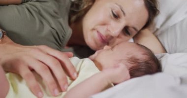 Yeni doğmuş bebeği öpen beyaz bir annenin videosu. annelik, ebeveyn sevgisi ve yeni doğan bebek konseptiyle ilgilenmek dijital olarak üretilmiş video.
