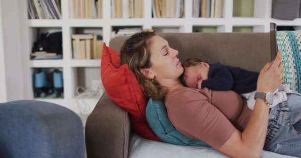Kafkasyalı Bir Annenin Tabletle Kanepeye Uzanmış Yeni Doğmuş Bir Bebekle — Stok video