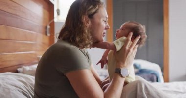 Yeni doğmuş bebekle oynayan mutlu beyaz bir annenin videosu. annelik, ebeveyn sevgisi ve yeni doğan bebek konseptiyle ilgilenmek dijital olarak üretilmiş video.