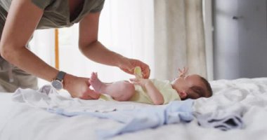 Beyaz bir annenin bebeğini değiştirdiği orta bölüm videosu. annelik, ebeveyn sevgisi ve yeni doğan bebek konseptiyle ilgilenmek dijital olarak üretilmiş video.