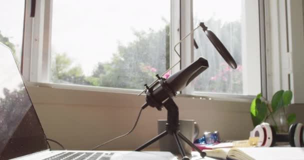 ノートパソコン マイク ヘッドフォン ノートパッドのビデオが机の上に横たわっています ホームオフィス 技術コンセプトで自宅から働く — ストック動画