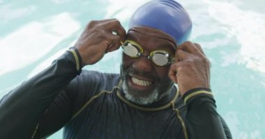 Video of happy senior african american men swimming in pool. Retirement lifestyle, active leisure time.