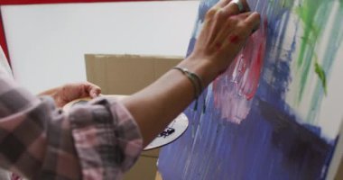 Stüdyoda iki ırklı kadın ressamın ellerinin videosu. Sanat, el sanatları, yaratıcılık ve yaratılış süreci kavramı.