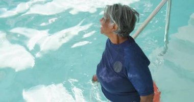 Havuzda yüzen yaşlı Afrikalı Amerikalı kadınların videosu. Emeklilik yaşam tarzı, aktif boş zaman.