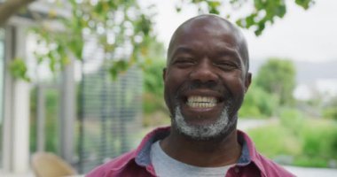 Video of happy senior american african men in the garden. Retirement lifestyle, spending time alone.
