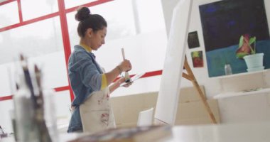 Stüdyoda iki ırklı kadın ressamın videosu. Sanat, el sanatları, yaratıcılık ve yaratılış süreci kavramı.