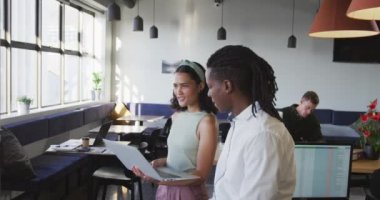 Çeşitli iş adamları iş hakkında konuşuyor ve ofiste dizüstü bilgisayar kullanıyorlar. Modern bir ofiste çalışıyorum..