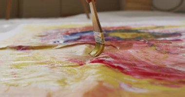 Video of close up of brush and artist painting. Art, crafts, creativity and creation process concept.