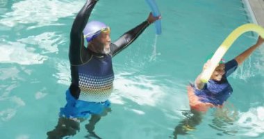 happy senior american african couple exercising in the pool. Retirement lifestyle, ,active leisure time.