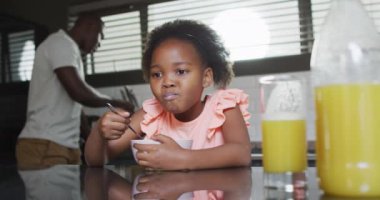 african american father and daughter preparing breakfast. Enjoying quality family time together at home.
