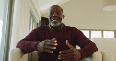 Video of thoughtful senior african american men sitting in living room alone. Retirement lifestyle, spending time alone.