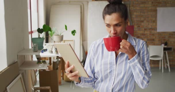 Video Happy Biracial Female Designer Using Tablet Drinking Coffee Studio — Vídeos de Stock