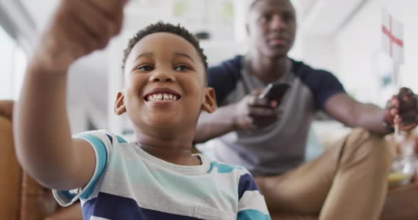Video Happy African American Father Son Sitting Sofa Watching Match — Vídeos de Stock