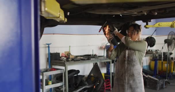 Video Biracial Female Car Mechanic Using Grinder Working Car Repair — ストック動画