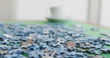 Bulmaca videosu ve kahve fincanları yeşil masada. Emeklilik yaşam tarzı, birlikte zaman geçirme, aktif boş zaman..