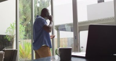 african american man using using smartphone. Domestic life, using technology at home.