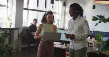 Çeşitli iş adamları iş hakkında konuşuyor ve ofiste dizüstü bilgisayar kullanıyorlar. Modern bir ofiste çalışıyorum..