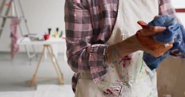 Çift ırklı kadın sanatçının kumaşla el temizleme videosu. Sanat, el sanatları, yaratıcılık ve yaratılış süreci kavramı.