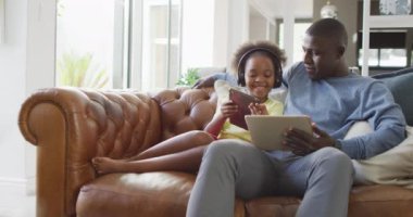  african american father and daughter using tablet. Enjoying quality family time together at home, using technology.