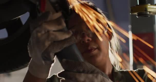 Video Biracial Female Car Mechanic Using Grinder Working Car Repair — Stockvideo