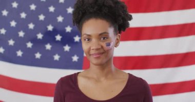 Video of excited afrcian american woman with flag of usa watching match in tv. Sport, cheering and emotions concept.