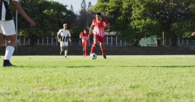 Video of diverse group of male football players playing football. Male football team, inclusivity and fitness in team sports.