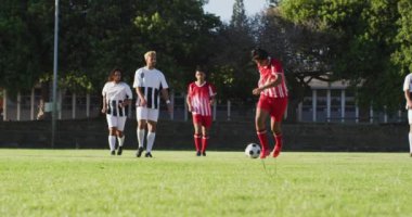 Video of diverse group of male football player on field, playing football. Male football team, inclusivity and fitness in team sports.