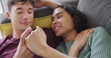 Kanepede uzanan ve oturma odasında kucaklaşan mutlu çift. Evde kaliteli zaman geçirmek.