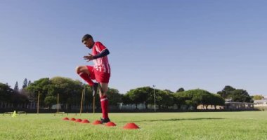 Video of diverse group of male football players warming up on field, running. Male football team, inclusivity and fitness in team sports.