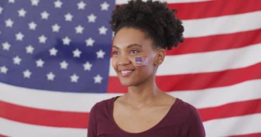 Video of excited afrcian american woman with flag of usa watching match in tv. Sport, cheering and emotions concept.