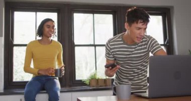 Kahve içen ve dizüstü bilgisayar kullanan mutlu çift. Evde kaliteli zaman geçirmek.