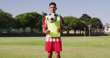 Video of biracial male football players with ball on field. Male football team, inclusivity and fitness in team sports.