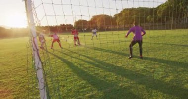 Video of diverse gorup of male football players on field,playing football. Male football team, inclusivity and fitness in team sports.