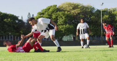 Video of diverse group of male football players playing football. Male football team, inclusivity and fitness in team sports.
