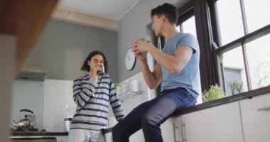 Kahve içen ve mutfakta konuşan mutlu çift. Evde kaliteli zaman geçirmek.