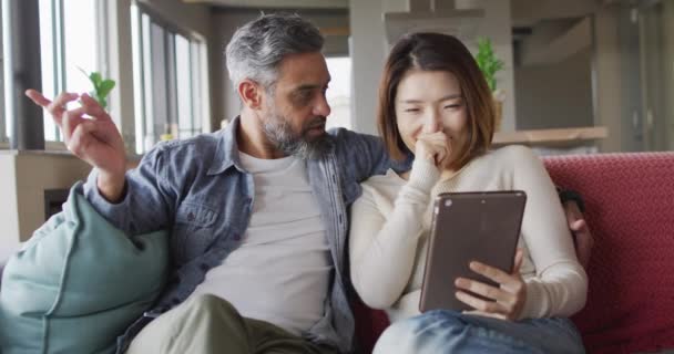 Happy Diverse Couple Sitting Living Room Tablet Talking Together Spending — Vídeo de stock