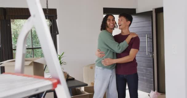 Happy Diverse Male Couple Moving House Talking Embracing Smiling Spending — Vídeo de Stock
