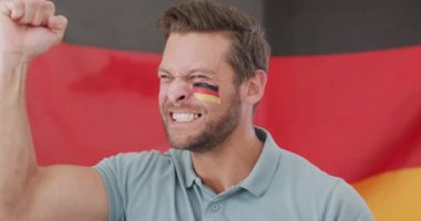 Video of excited caucasian man with flag of germany watching match in tv. Sport, cheering and emotions concept.