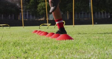 Video of diverse group of male football players warming up and jumping. Male football team, inclusivity and fitness in team sports.