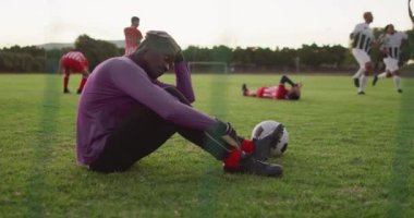 Video of diverse group of male football player on field, playing football. Male football team, inclusivity and fitness in team sports.