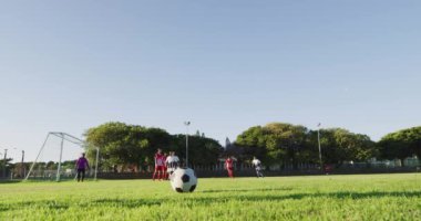 Video of diverse group of male football player on field, playing football. Male football team, inclusivity and fitness in team sports.