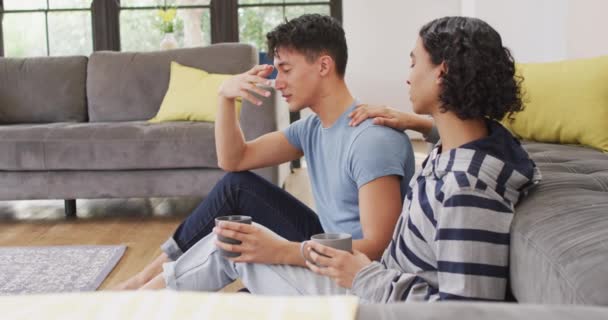 Worried Diverse Male Couple Sitting Floor Drinking Coffee Living Room — 图库视频影像