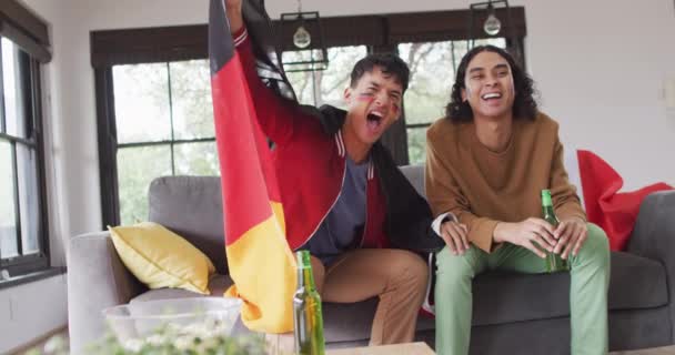 Feliz Pareja Masculina Diversa Viendo Televisión Con Banderas Nacionales Apoyo — Vídeos de Stock