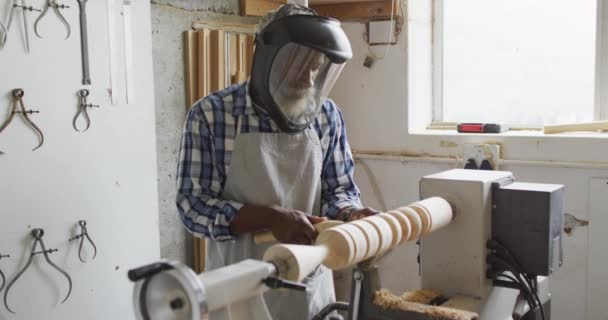 African American Male Carpenter Wearing Protective Helmet Turning Wood Lathe — Αρχείο Βίντεο