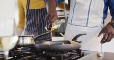 Video of midsection of african american couple cooking together. Love, relationship and spending quality time together concept.