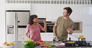 Video of happy diverse couple preparing meal together. Love, relationship and spending quality time together concept.
