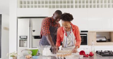 Video of happy african american couple baking together and having fun with flour. Love, relationship and spending quality time together concept.