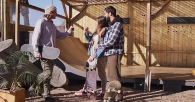 Video of happy diverse female and male skateboarders in skate park. Skateboarding, sport, active lifestyle and hobby concept.