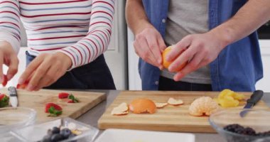 Video of midsection of diverse couple preparing fruits for juice. Love, relationship and spending quality time together concept.